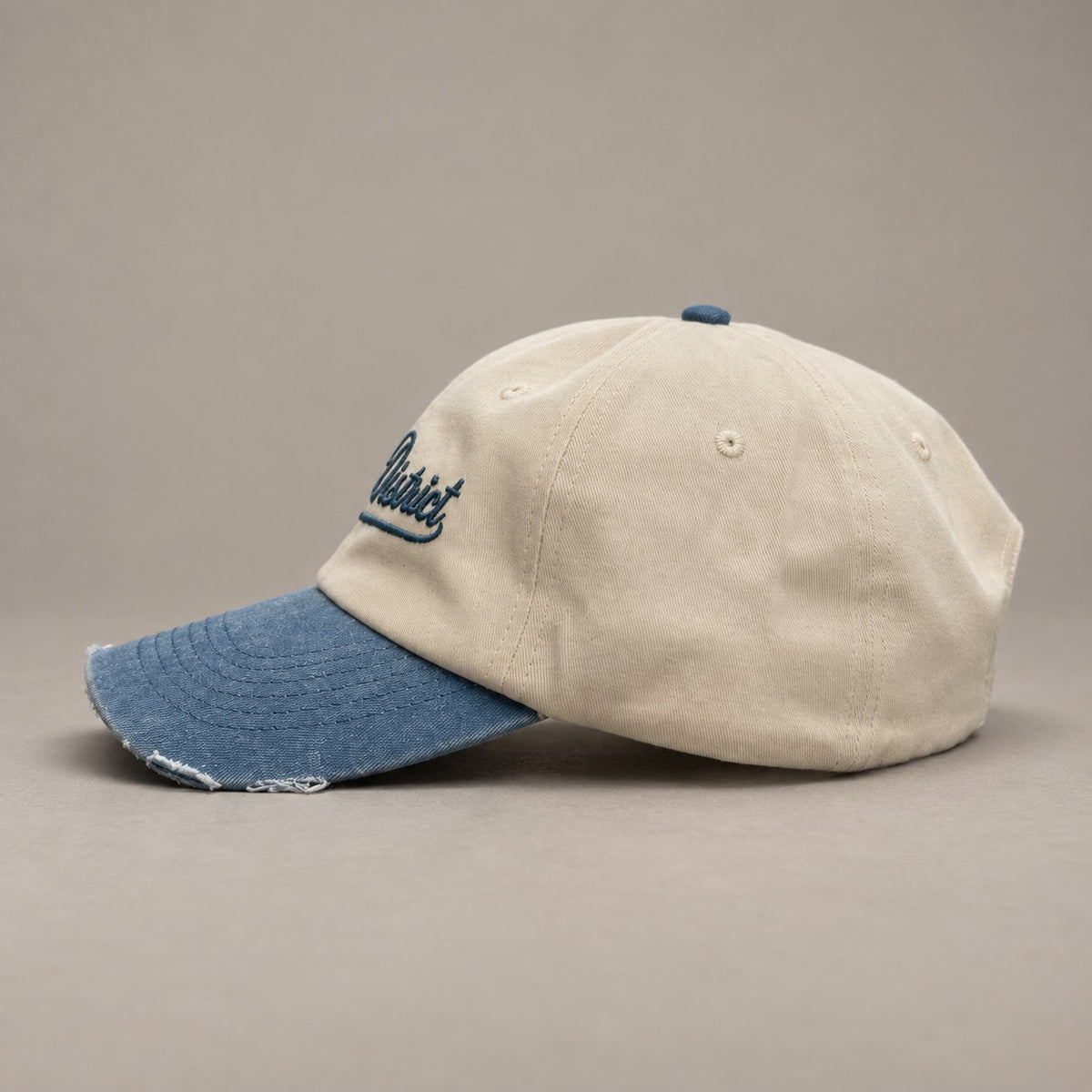 KRWN DISTRICT The Culture Two-Tone — low-profile vintage dad cap, side view with distressed indigo visor (AI-generated)