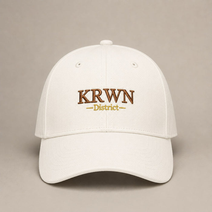 KRWN District Baseball Cap — Rule the District '26, front view with KRWN District embroidery on cream cotton canvas