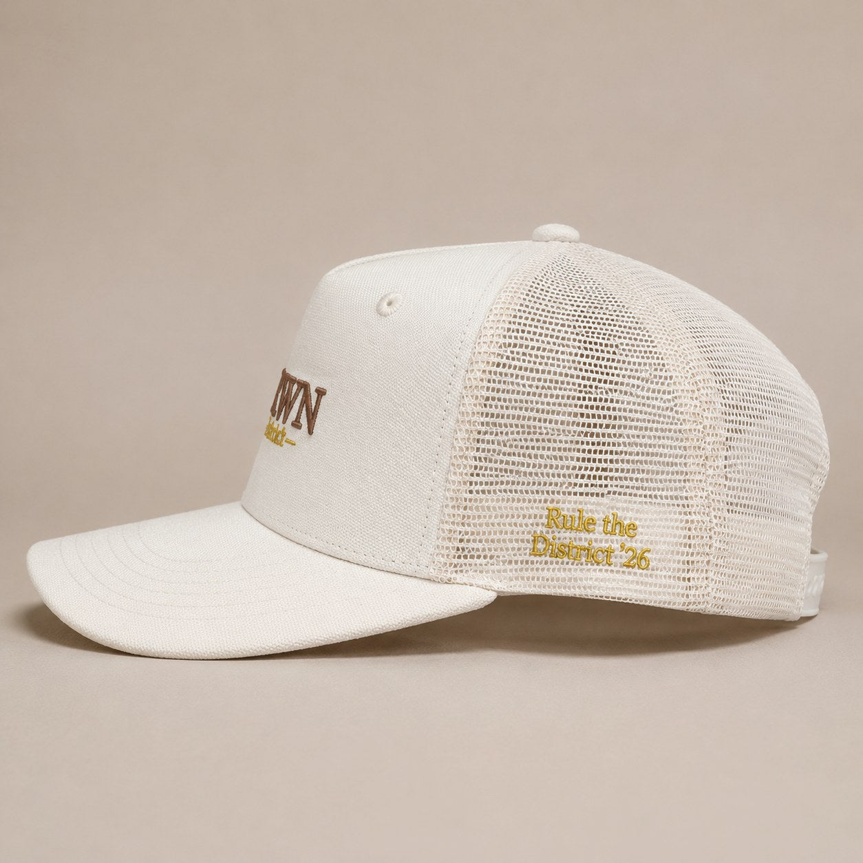 KRWN District Trucker Cap — side view with gold Rule the District '26 embroidery on breathable mesh